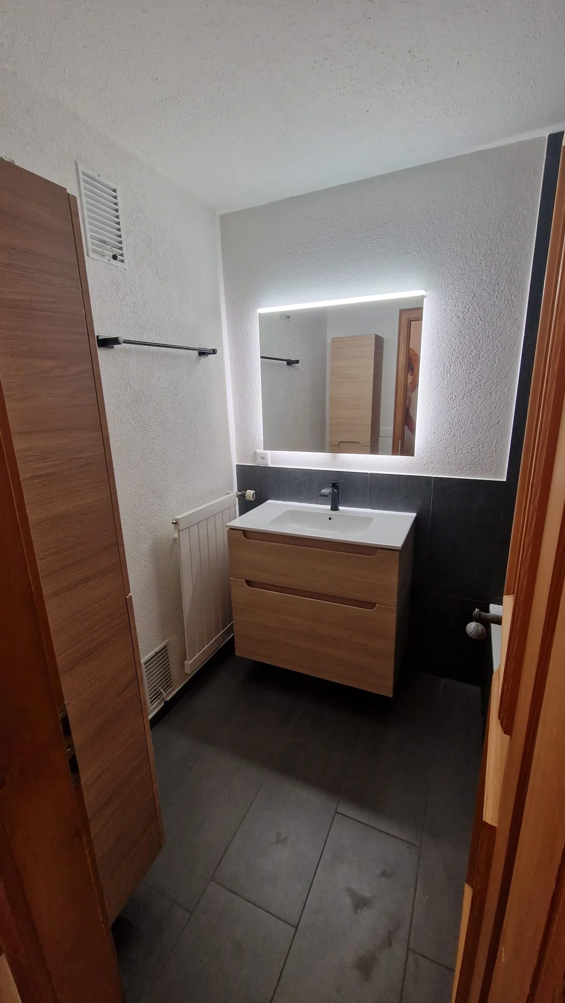 Modernes Bad mit Holz-Waschtisch und LED-Spiegel