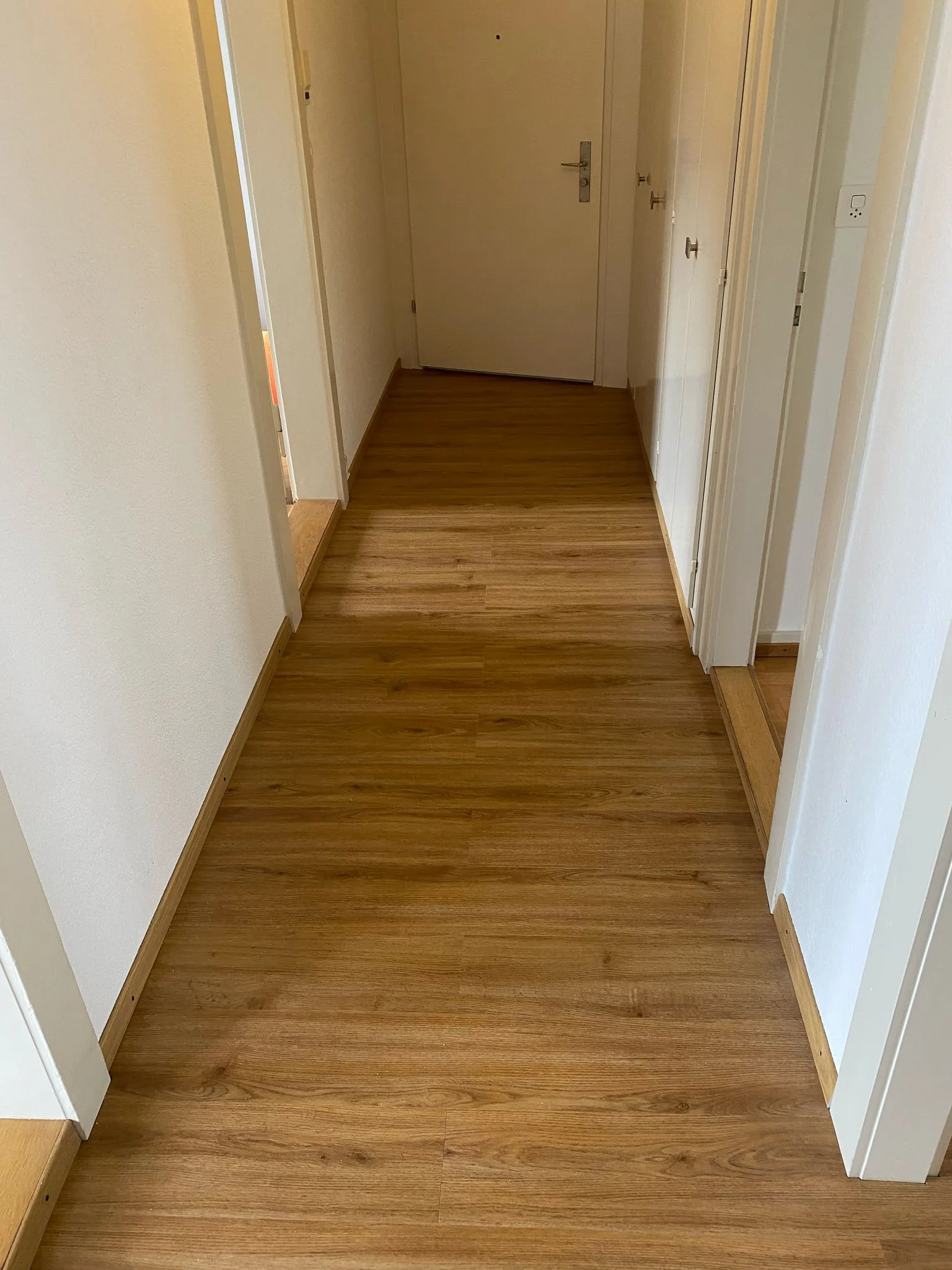 Korridor mit altem Boden und fertigem neuem Boden — gleiche Ansicht — nachher